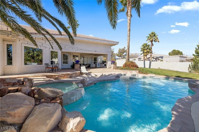 view of swimming pool featuring an in ground hot tub, pool water feature, and a patio