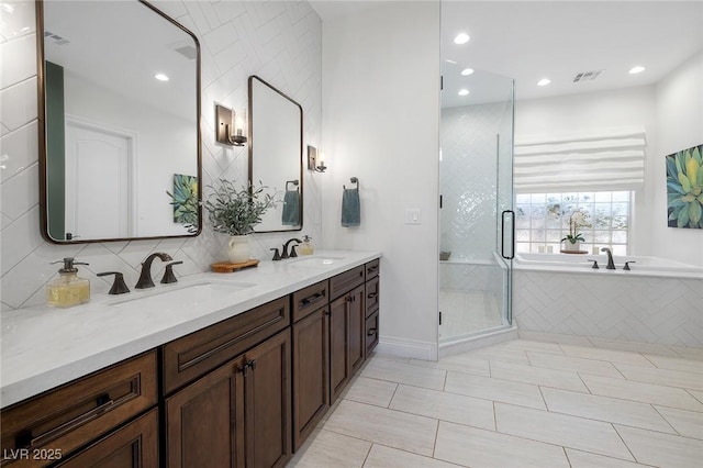 bathroom with vanity, backsplash, and independent shower and bath