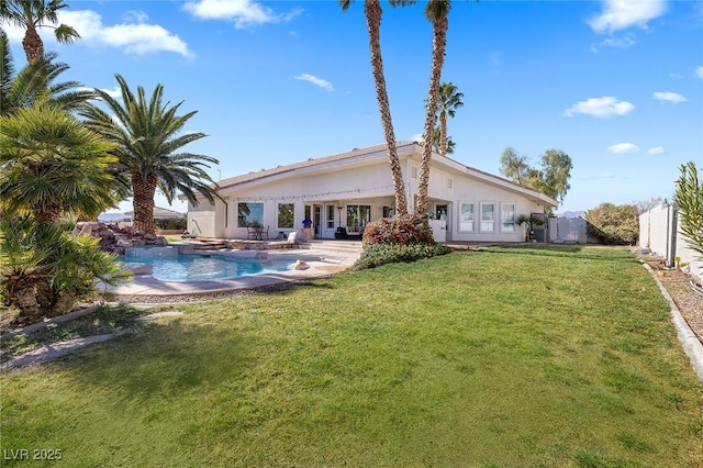 rear view of house featuring a fenced in pool, a lawn, and a patio area