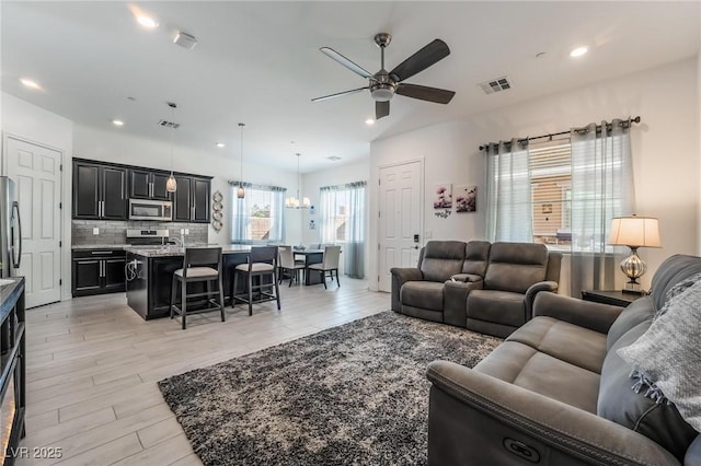 living room with light hardwood / wood-style floors and ceiling fan