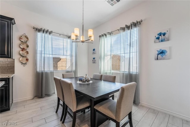 dining space featuring a wealth of natural light and a notable chandelier