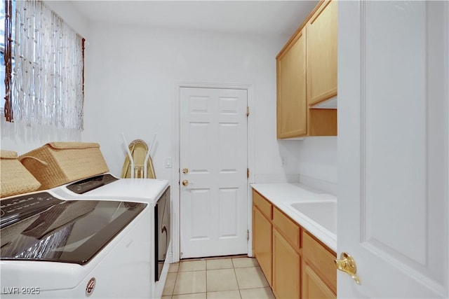 laundry area with cabinets, separate washer and dryer, sink, and light tile patterned floors