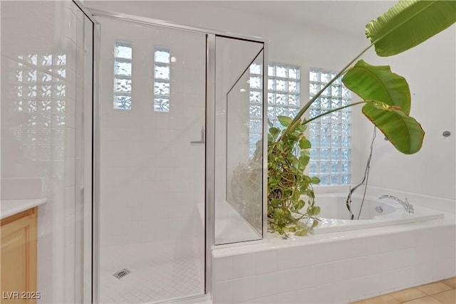 bathroom with independent shower and bath and tile patterned flooring