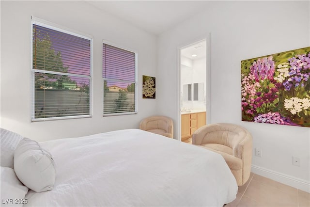 bedroom featuring ensuite bath and light tile patterned floors