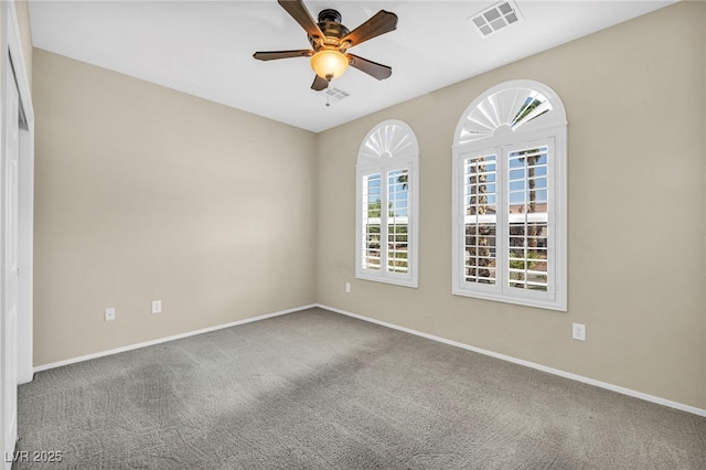 carpeted empty room with visible vents, a ceiling fan, and baseboards