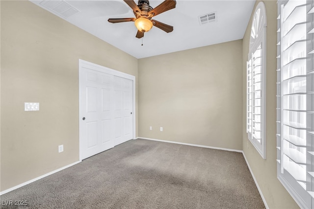 unfurnished bedroom with multiple windows, carpet floors, and ceiling fan