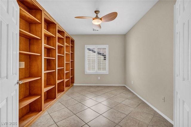 empty room featuring light tile patterned floors, ceiling fan, and baseboards