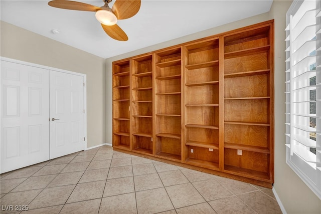 unfurnished bedroom with light tile patterned floors, a closet, multiple windows, and baseboards