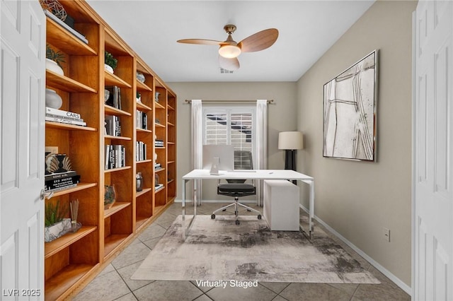 tiled office space featuring a ceiling fan and baseboards