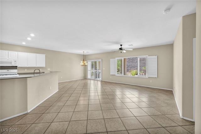 unfurnished living room featuring ceiling fan with notable chandelier, light tile patterned floors, and sink