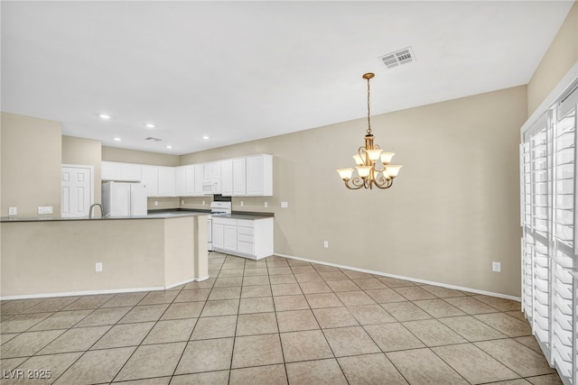 kitchen with white appliances, a chandelier, dark countertops, visible vents, and pendant lighting