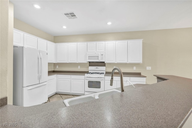 kitchen with white cabinetry, a sink, visible vents, recessed lighting, and white appliances