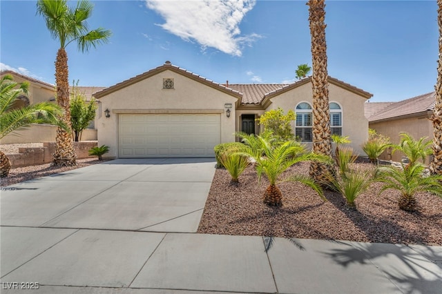 mediterranean / spanish home with a garage, stucco siding, driveway, and a tiled roof