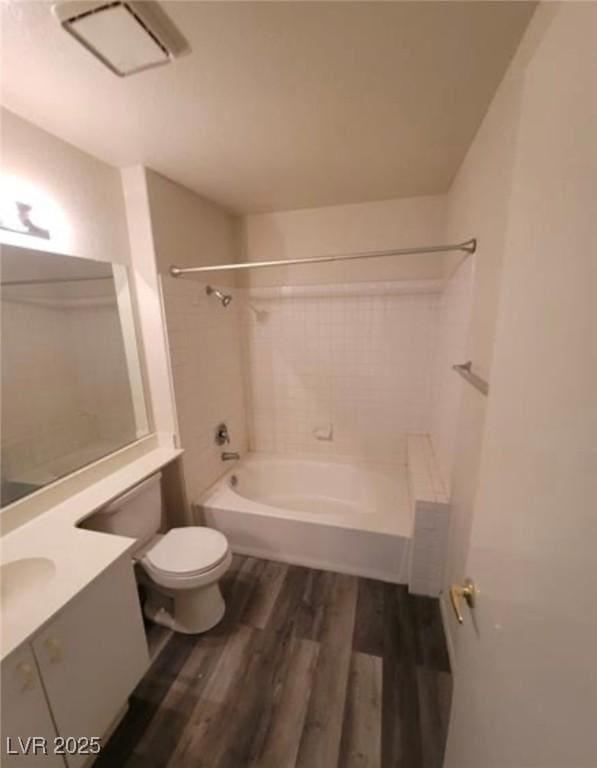 full bathroom featuring tiled shower / bath combo, wood-type flooring, vanity, and toilet