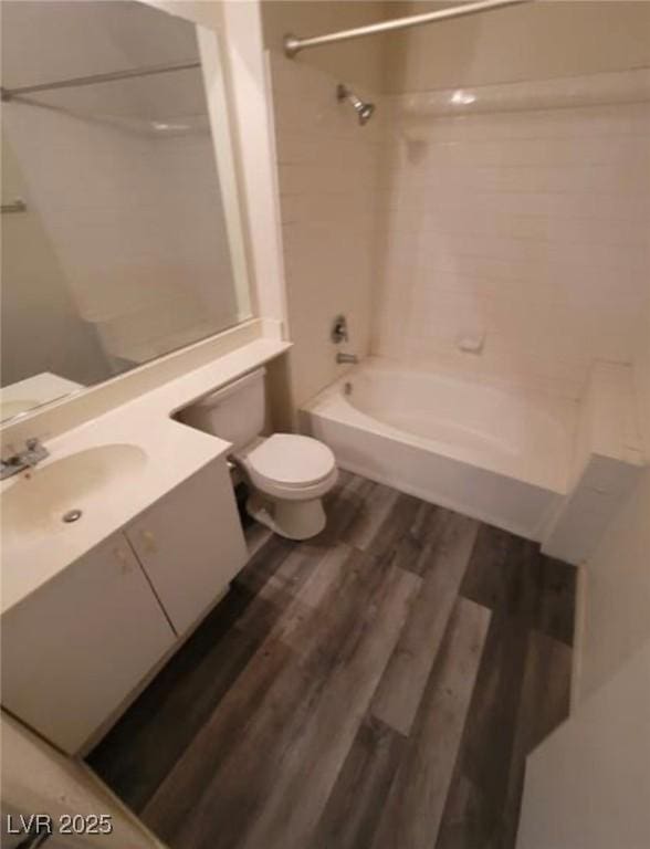 full bathroom with hardwood / wood-style flooring, vanity, toilet, and tiled shower / bath combo