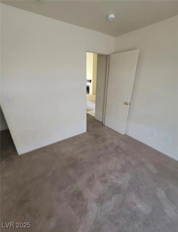 unfurnished room with dark colored carpet