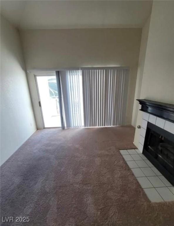 unfurnished living room with a tile fireplace and light carpet