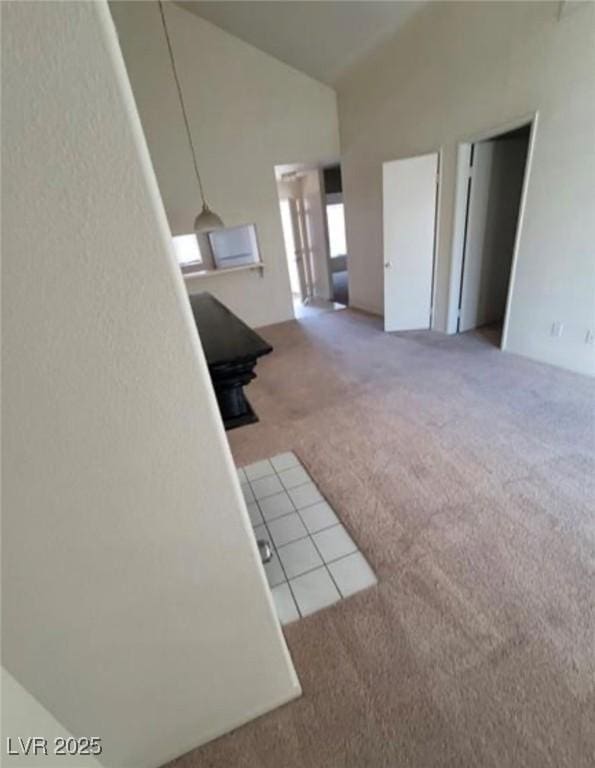 carpeted living room with high vaulted ceiling