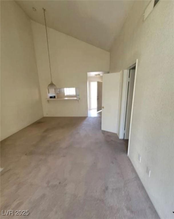 interior space featuring high vaulted ceiling and concrete floors