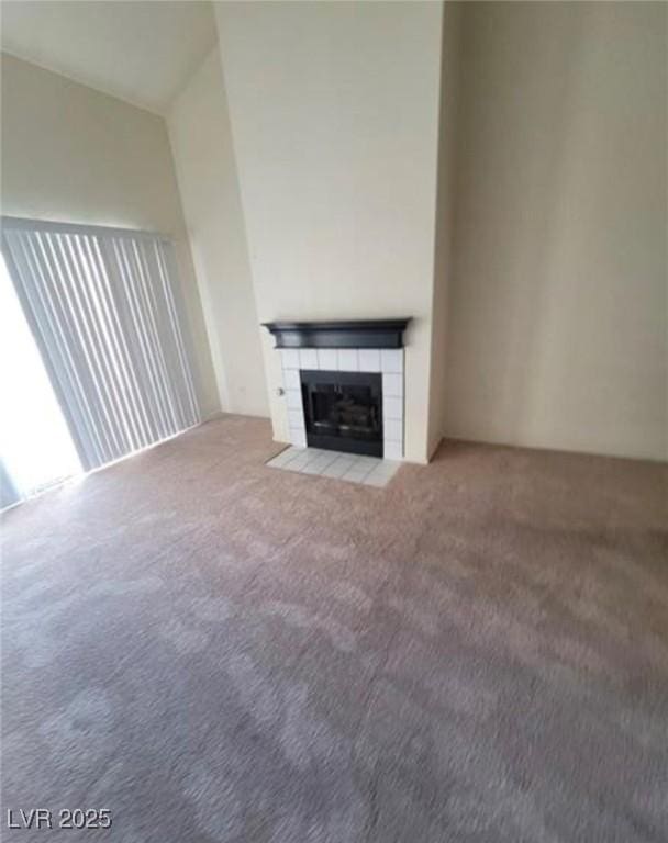 unfurnished living room featuring a tile fireplace and carpet flooring