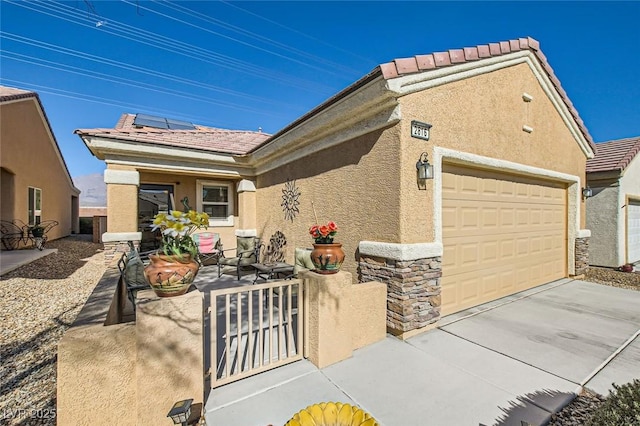 view of front of property featuring a garage and solar panels