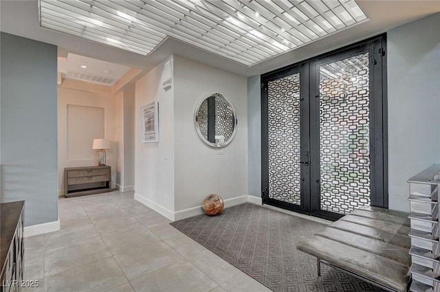 entryway with light tile patterned floors and french doors