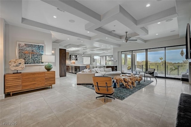 tiled living room with beam ceiling, coffered ceiling, and ceiling fan