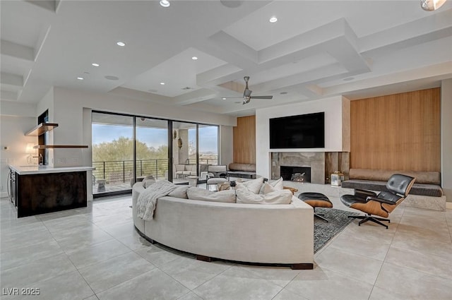 living room featuring beamed ceiling, a high end fireplace, coffered ceiling, and light tile patterned flooring