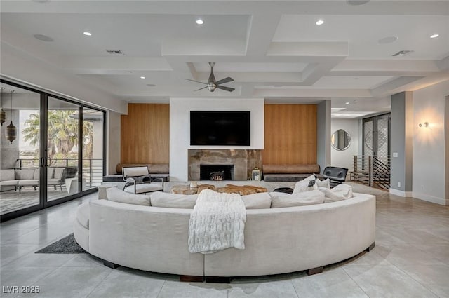 living room featuring coffered ceiling, beamed ceiling, and ceiling fan