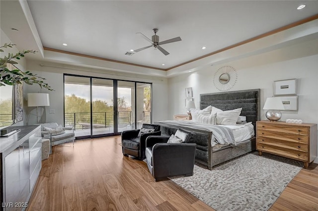 bedroom with hardwood / wood-style flooring, access to outside, ceiling fan, a raised ceiling, and crown molding