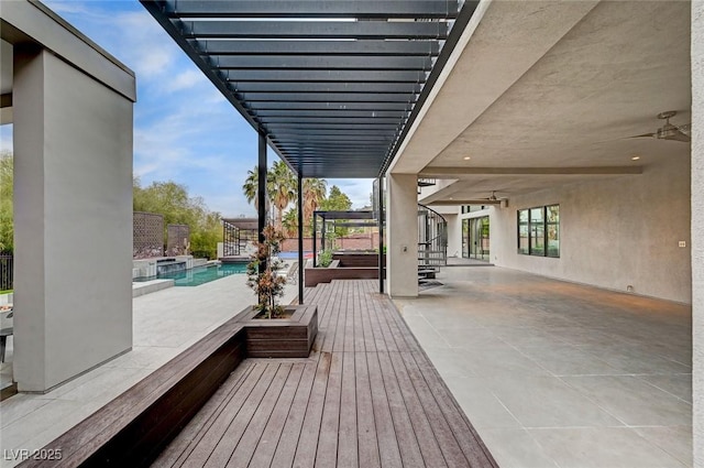 view of patio / terrace with ceiling fan and a pool with hot tub