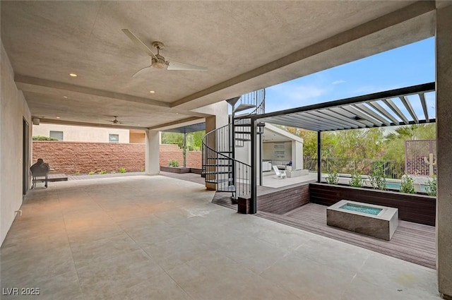 view of patio with ceiling fan and a fire pit