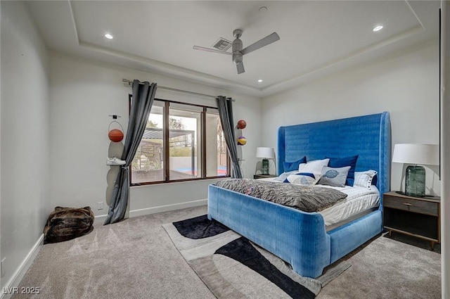 bedroom featuring ceiling fan, a raised ceiling, and light carpet