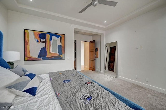 bedroom with ceiling fan, carpet flooring, and a raised ceiling