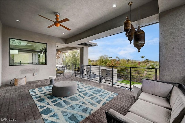 wooden deck with an outdoor living space and ceiling fan