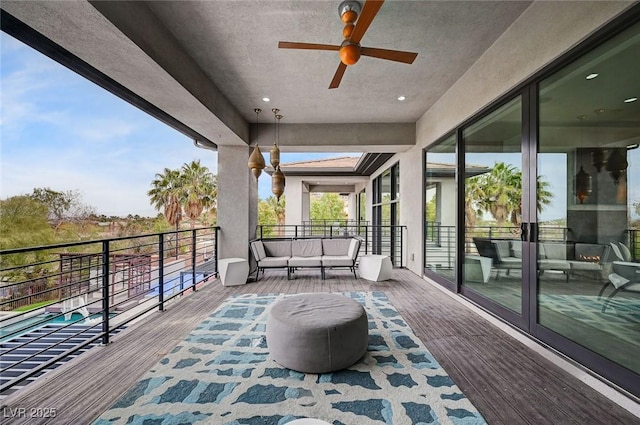 wooden terrace with an outdoor living space and ceiling fan