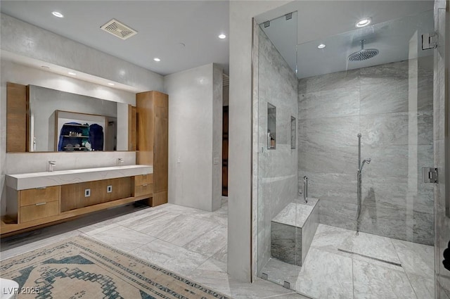 bathroom featuring a shower with door and vanity