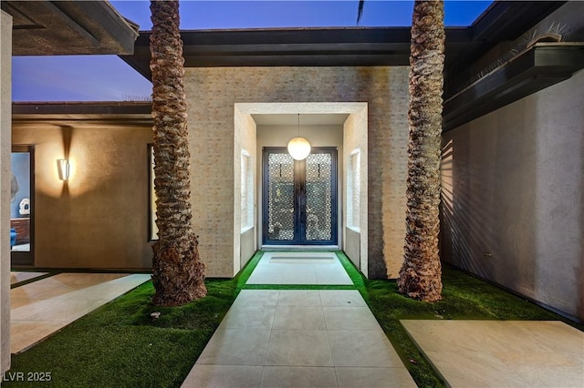 exterior entry at dusk featuring french doors