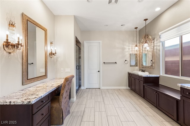 bathroom featuring vanity, an inviting chandelier, and a shower with shower door