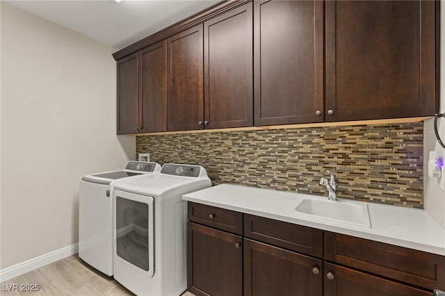 laundry room featuring cabinets, washing machine and dryer, and sink