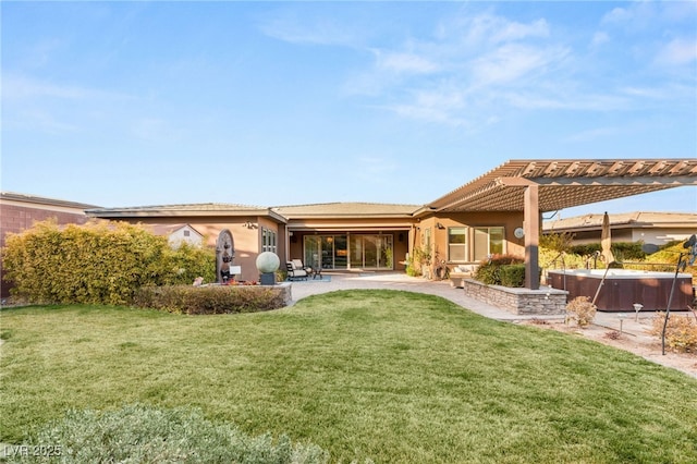 rear view of property featuring a yard, a hot tub, a pergola, and a patio