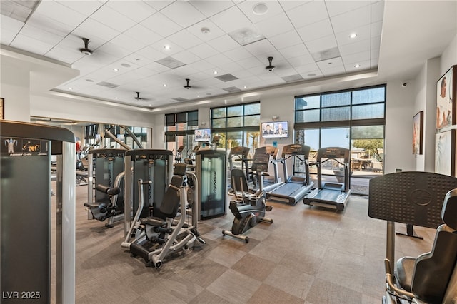 gym with a paneled ceiling and a tray ceiling