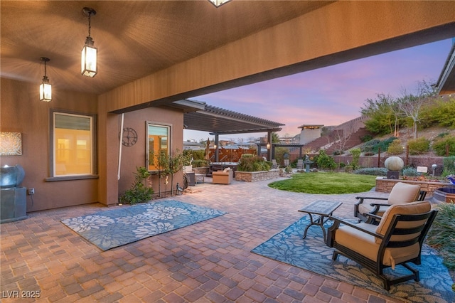 patio terrace at dusk featuring a pergola and a lawn