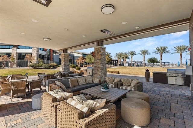 view of patio / terrace with exterior kitchen, area for grilling, and an outdoor living space