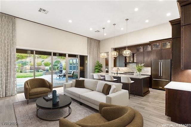 10179 Emerald Sunset Ct, Las Vegas, NV 89148 - living room with a towering ceiling, recessed lighting, and light wood-style floors