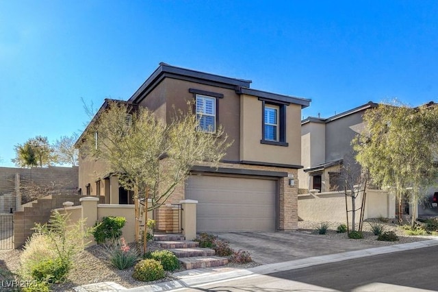 view of front facade featuring a garage, driveway, fence, and stucco siding