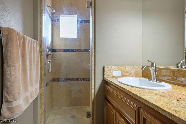 bathroom with a shower with door and vanity