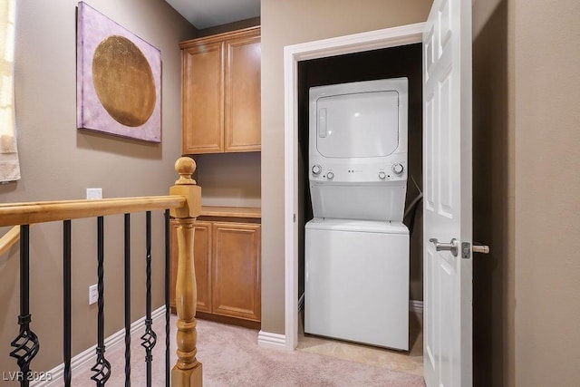 washroom featuring stacked washer and clothes dryer and light carpet