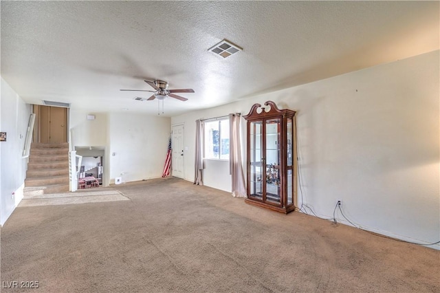 unfurnished living room with ceiling fan, carpet, and a textured ceiling