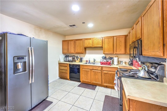 kitchen with light tile patterned flooring, sink, and black appliances